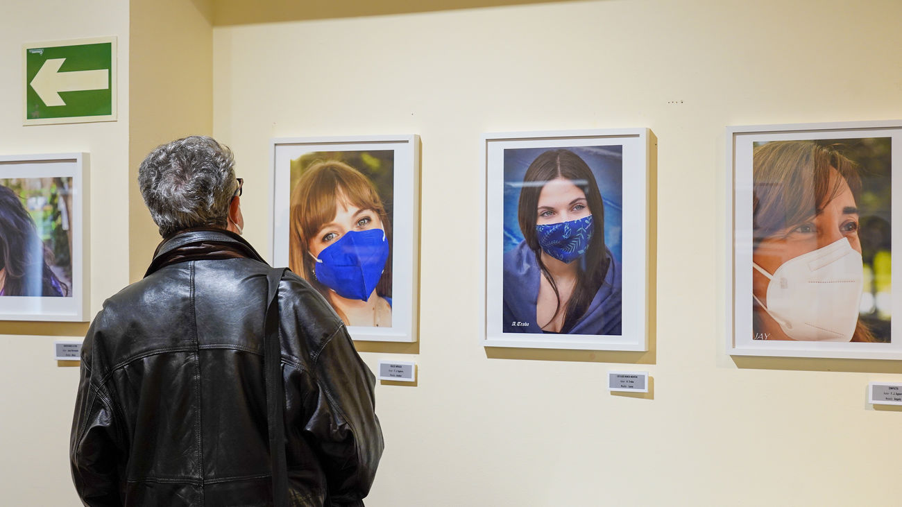 Una persona contempla algunas de las fotos de la exposición 'Miradas', en Móstoles