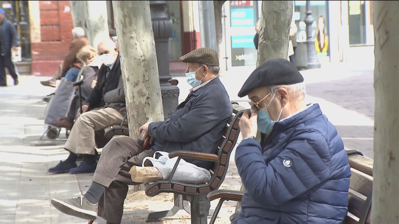 Personas mayores sentadas en una calle