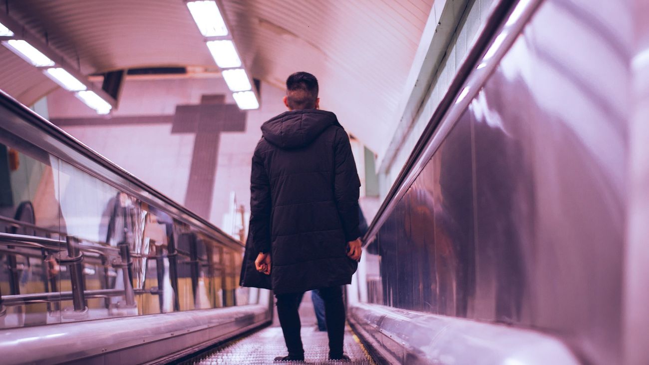 Hombre bajando por las escaleras mecánicas del metro de Madrid
