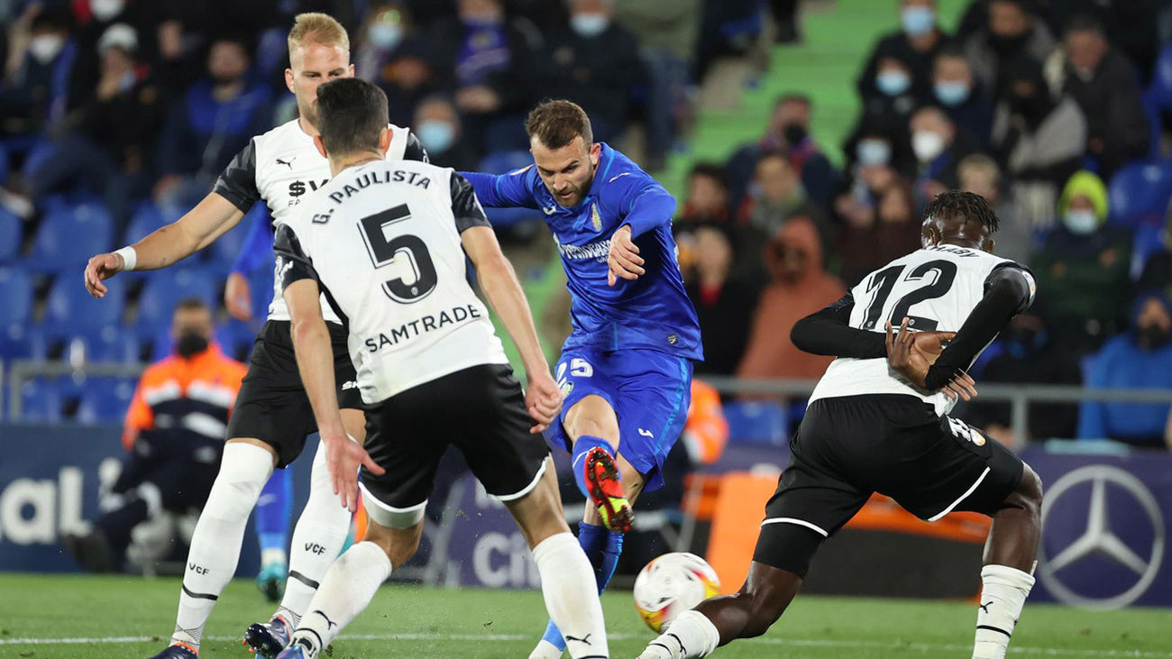 Borja Mayoral golpea el balón ante los defensores del Valencia