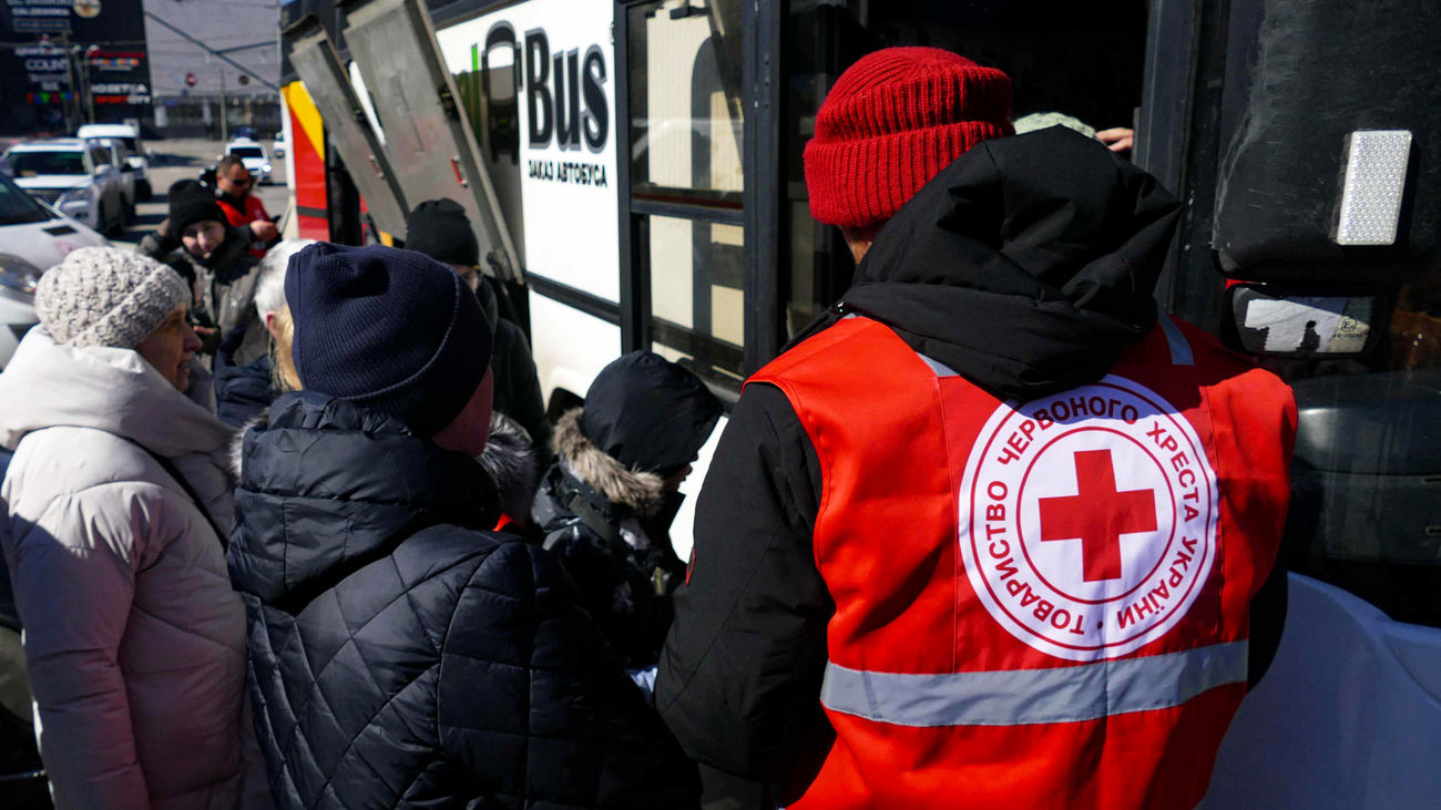 Un miembro de la Cruz Roja Internacional ayudando a refugiados ucranianos