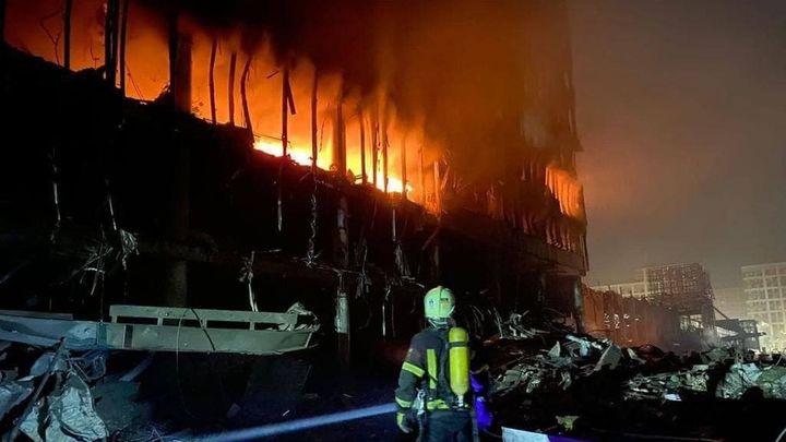 Un bombero observa el centro comercial en llamas en en el distrito de Podilskyi de Kiev. / EUROPA PRESS