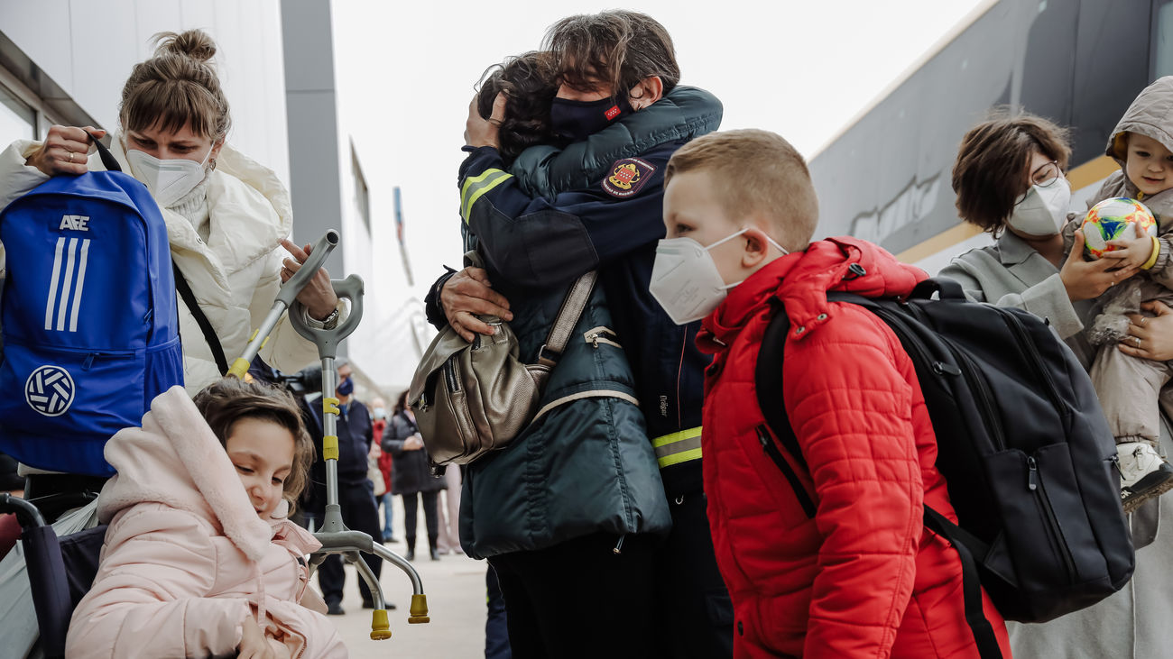 Un bombero abraza a una refugiada a su llegada al Hospital Zendal de Madrid