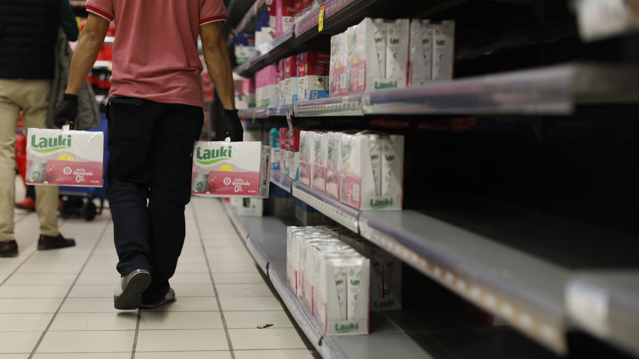 Un reponerdor con dos cajas de leche Lauki, en un supermercado Carrefour