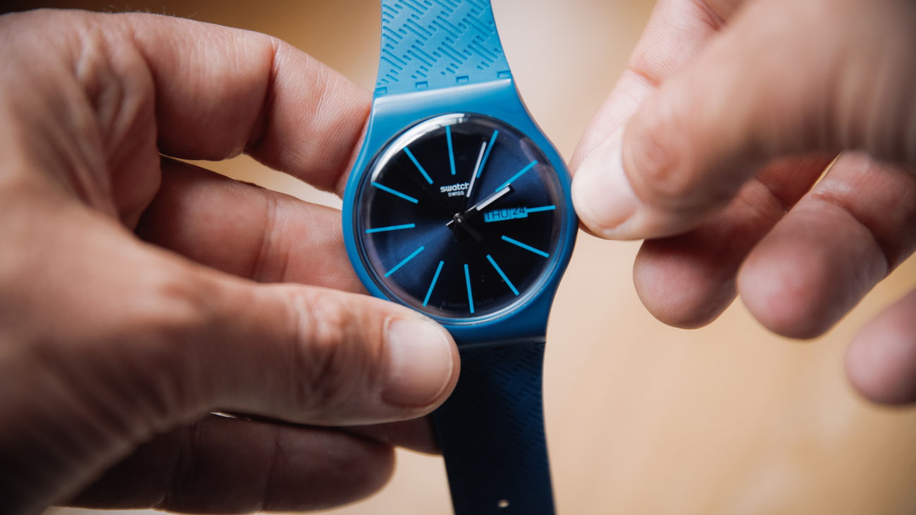 Una persona cambia la hora con las manecillas de reloj