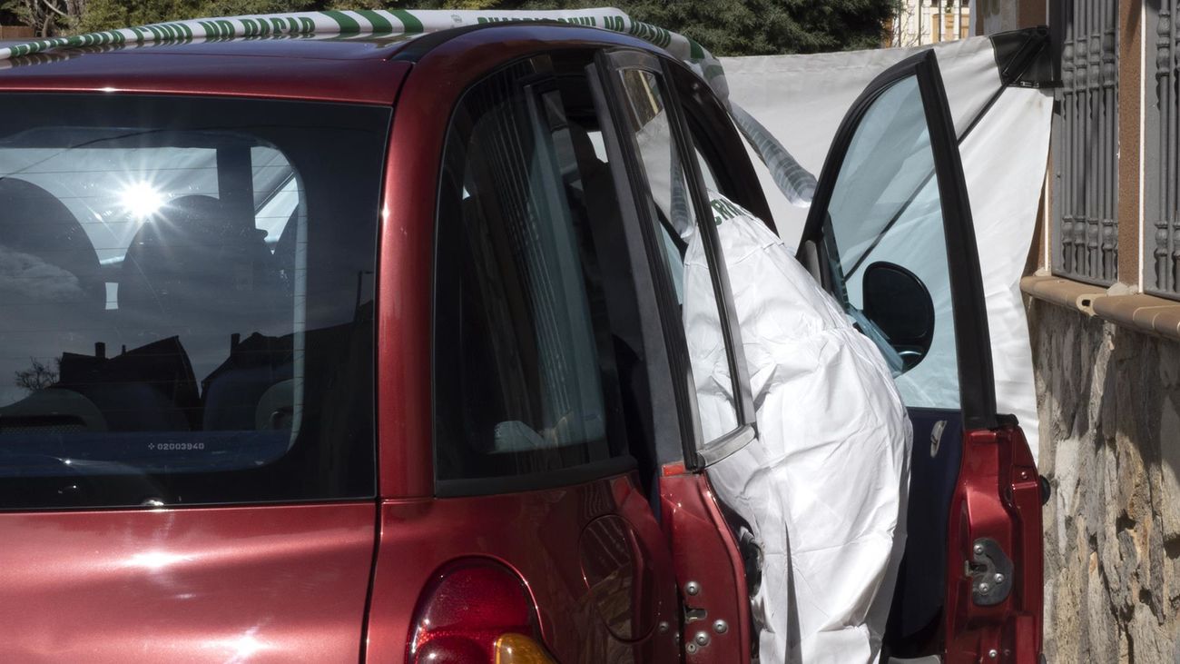 Un agente busca pruebas en un vehículo precintado por la Guardia Civil en Nohales (Cuenca) donde un varón de 43 años ha sido detenido como autor de la muerte de una mujer de 47 años
