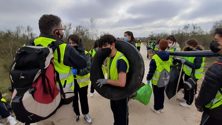 Un profesor indica a los alumnos dónde depositar los restos que han recogido / P.O.