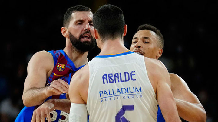 El ala-pívot del Barcelona Nikola Mirotic (i) se encara con Alberto Abalde (c), alero del Real Madrid, durante el partido de la Liga Endesa que disputan Barcelona y Real Madrid este domingo en el pabellón Palau Blaugrana / EFE