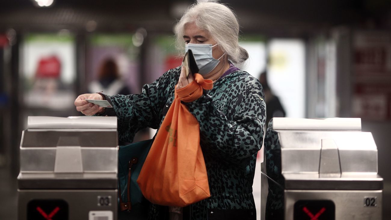 Una mujer franquea un torno al pasar su abono transporte