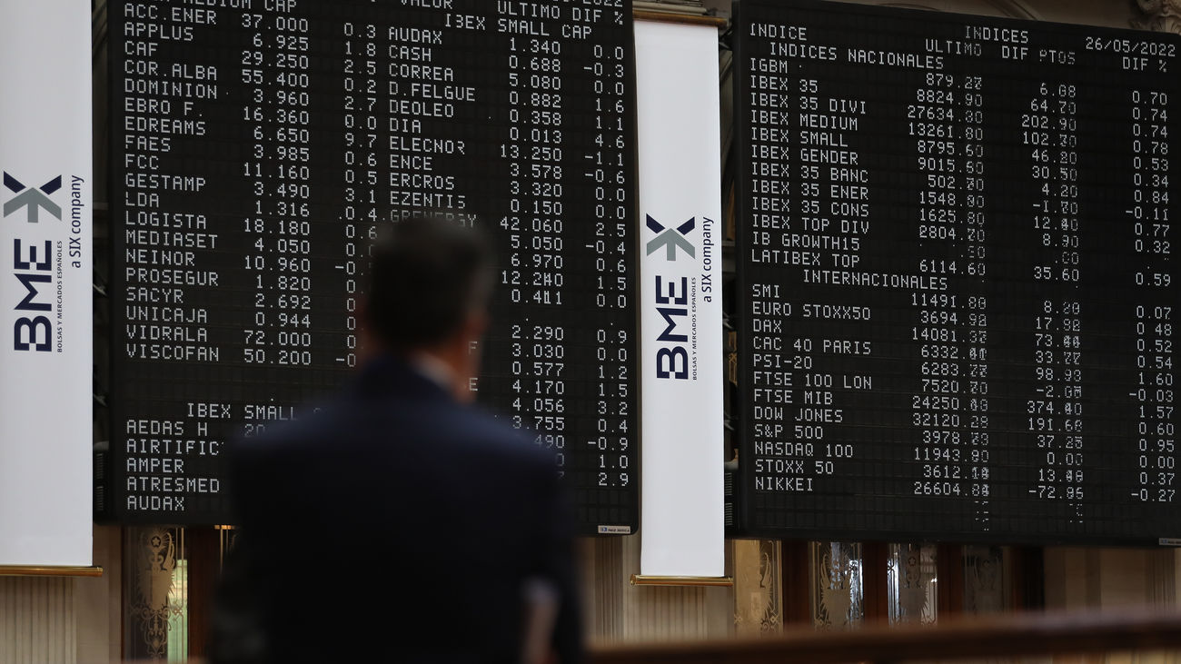 Un hombre frente a los paneles de valores del IBEX 35 en el Palacio de la Bolsa de Madrid