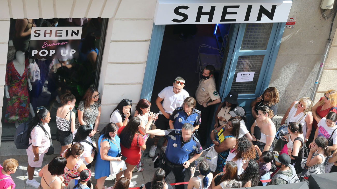 Dos agentes de la Policía Municipal coordinan la cola de gente para entrar a la primera tienda física de SHEIN en Madrid