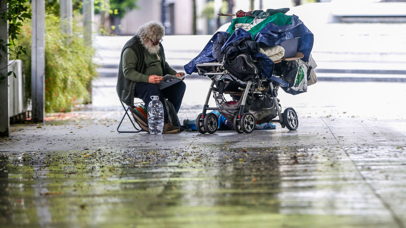 Una persona sin techo se refugia de la lluvia en Sevilla