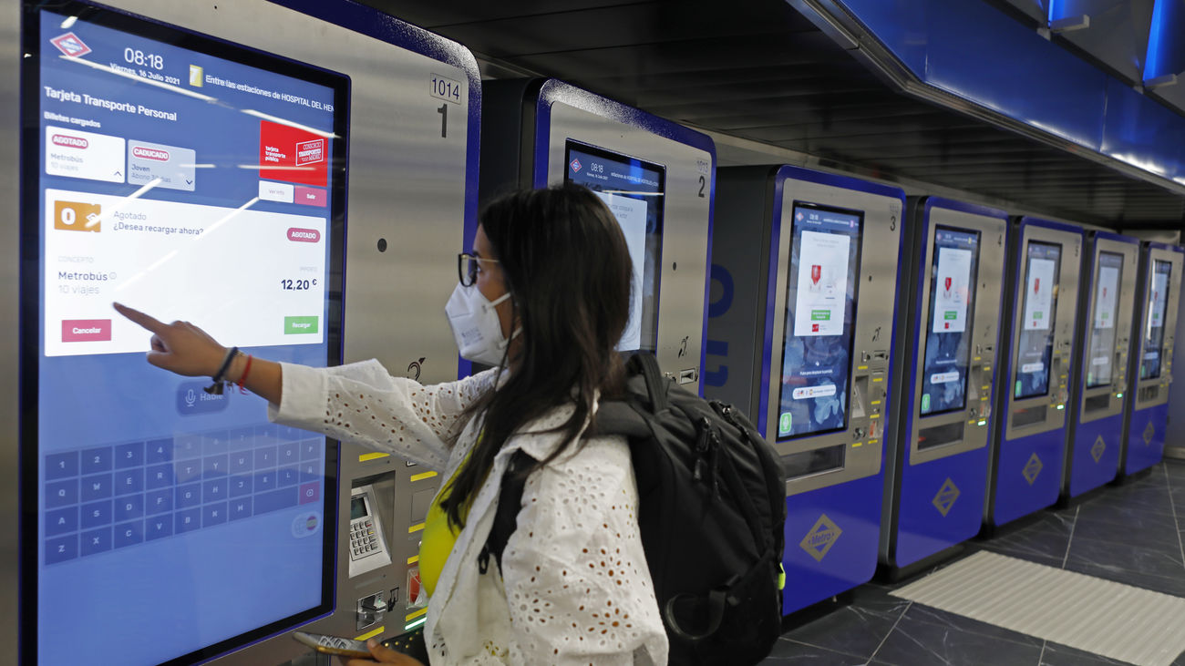 Una mujer compra un abono de 10 viajes en una pantalla táctil en la estación de metro de Gran Vía