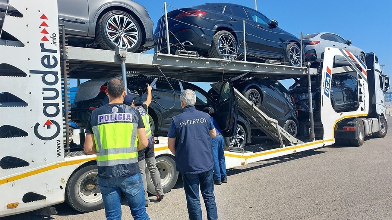 Policías junto a parte de los vehículos recuperados en España