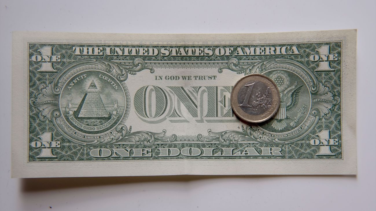 Una moneda de un euro sobre un billete de un dólar