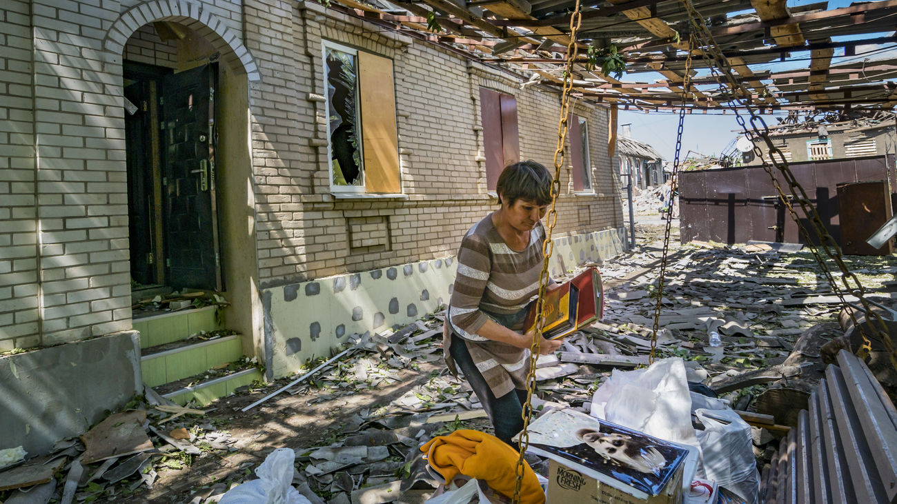Una mujer recoge sus pertenencias en su casa, destruida por un misil ruso en Druzhkivka, Donbás
