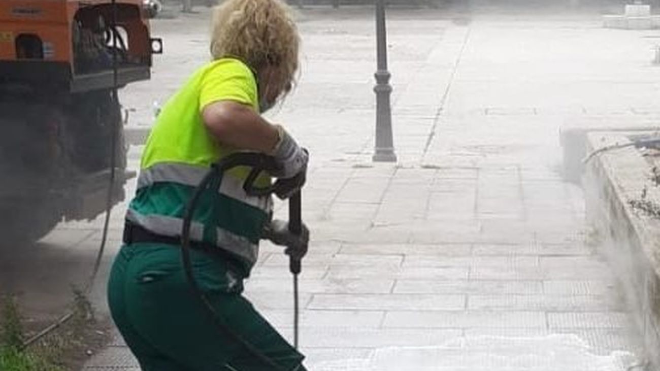 Una operaria del servicio de limpieza de Alcalá baldea una calle