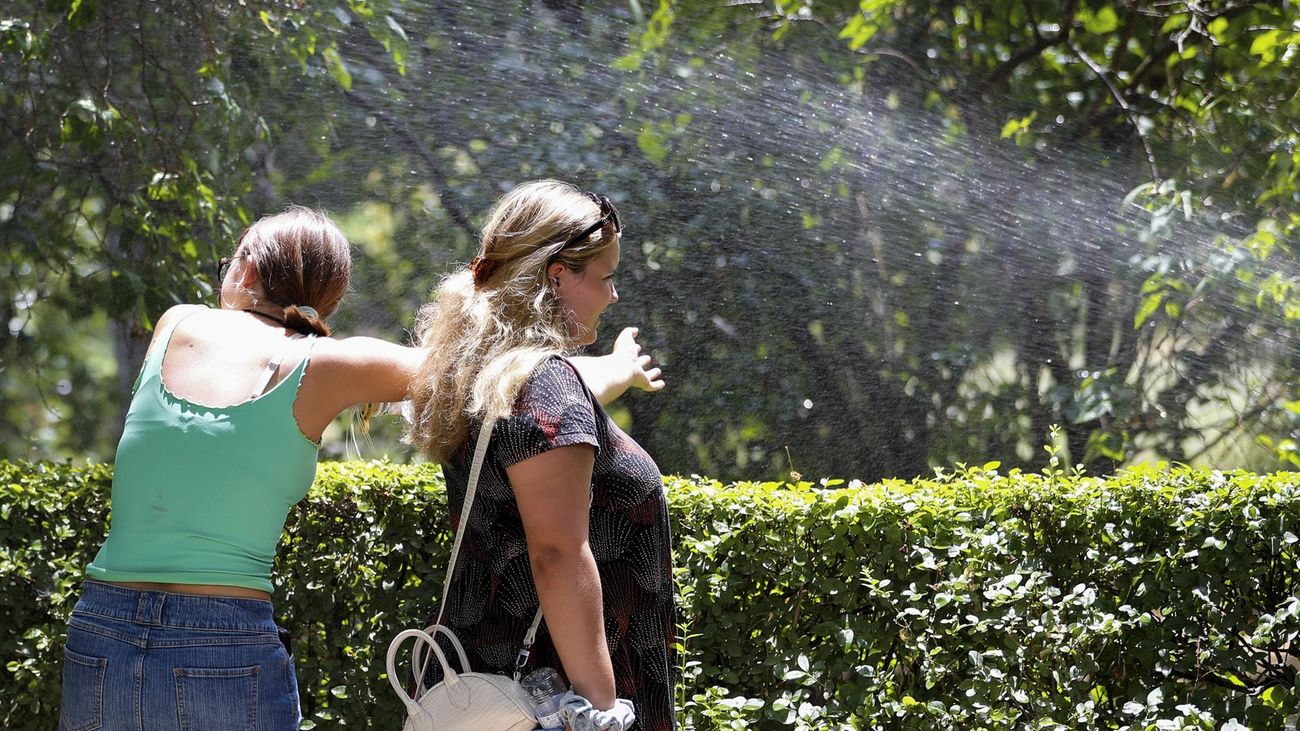 Unas mujeres se refrescan en Madrid por la ola de calor