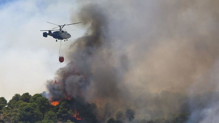 Un helicóptero del servicio de bomberos trabaja en el incendio declarado en la sierra de Mijas, Málaga / EFE