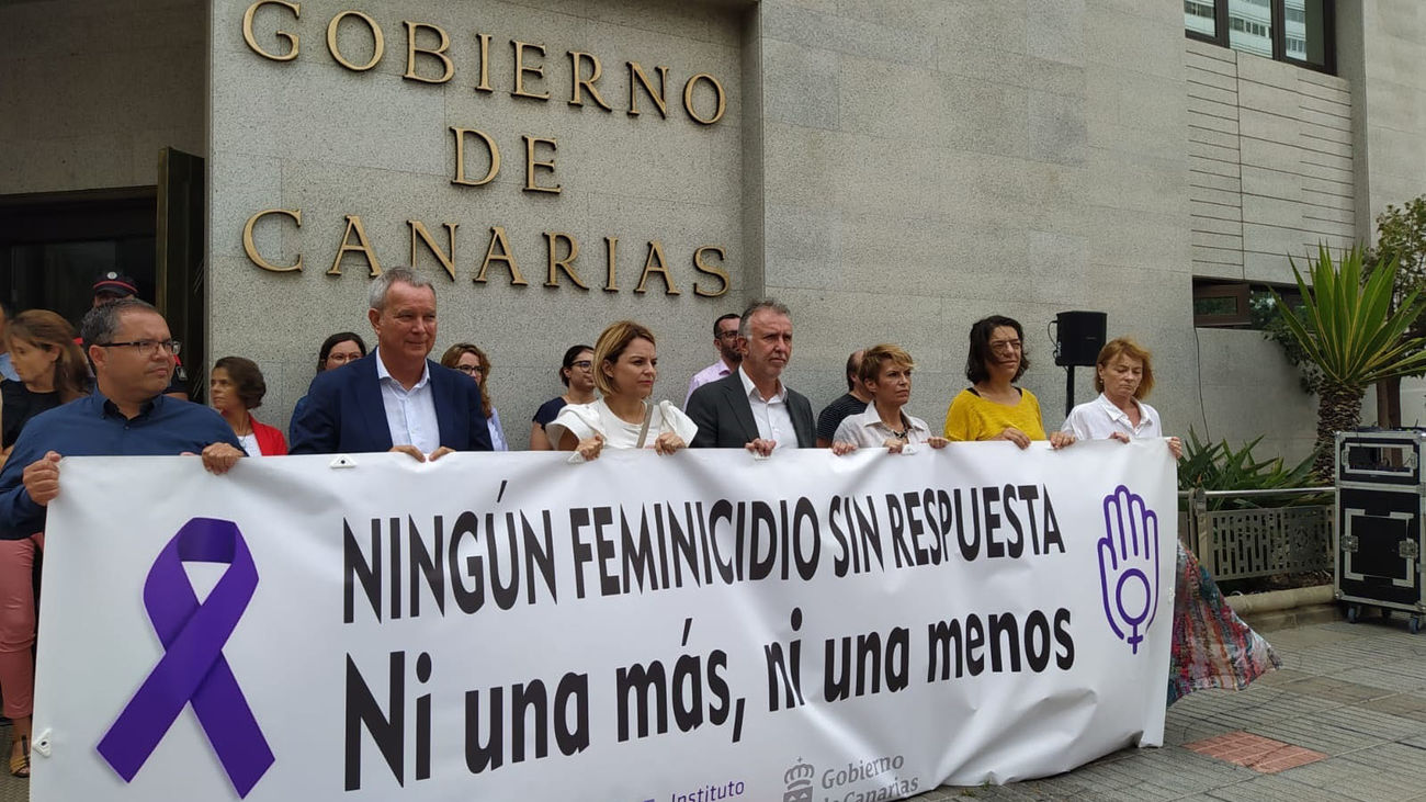 El presidente del Gobierno de Canarias, Ángel Víctor Torres, y parte de su equipo cogiendo la pancarta de rechazo contra el último asesinato de una mujer por violencia de género en Santa Cruz de Tenerife