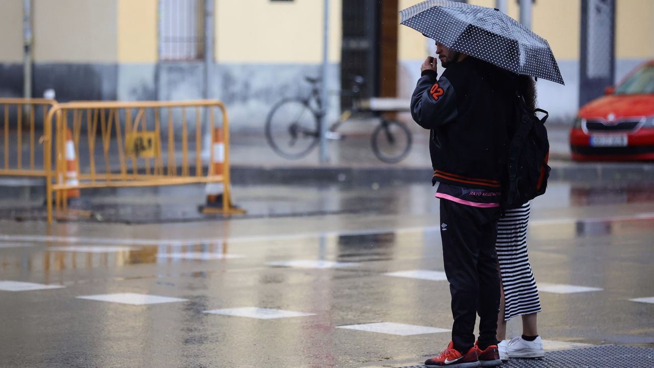 Un hombre camina con paraguas en Madrid