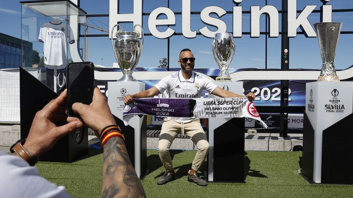Aficionado del Real Madrid posa con los trofeos / EFE
