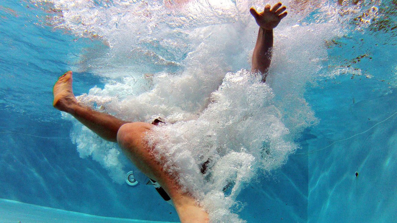 Una persona se zambulle en una piscina