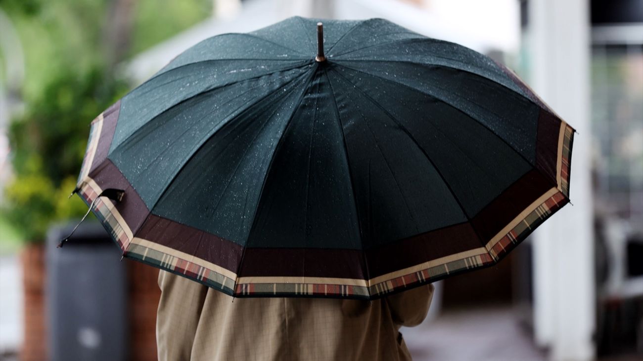Una persona camina con paraguas en Madrid