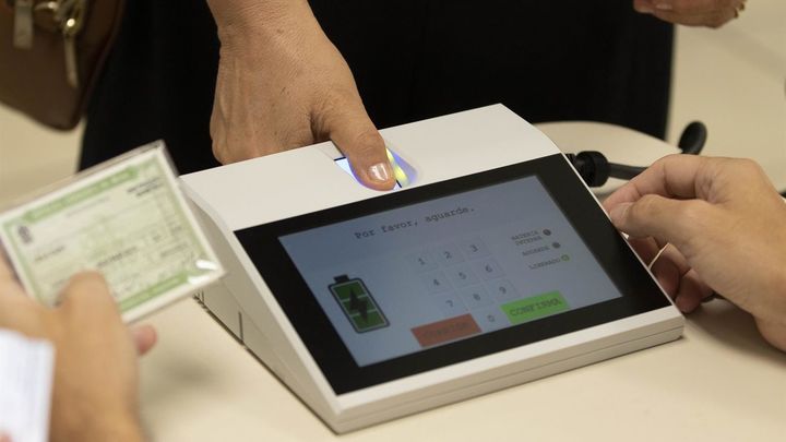 Una persona haciendo identificación biométrica antes de votar este domingo en una escuela de Brasilia / EFE