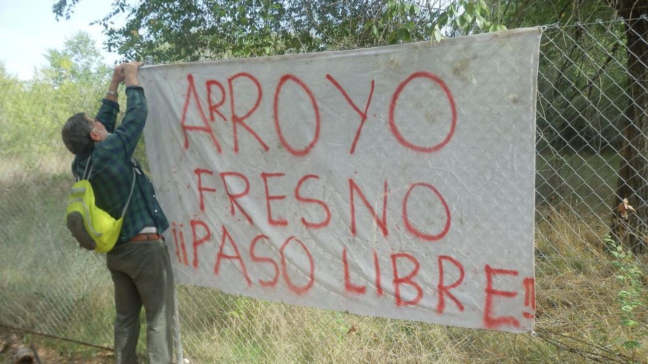 Una persona coloca una pancarta reclamando el acceso a una parte del camino