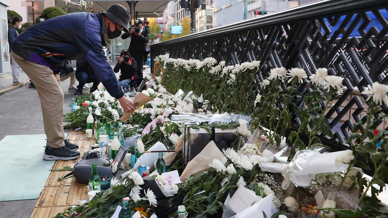 Personas depositando ramos de flores en el lugar de la tragedia