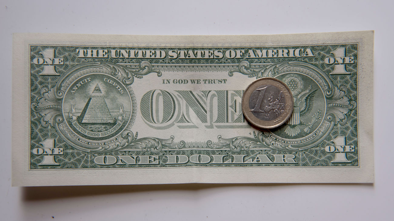 Una moneda de euro y un billete de dólar