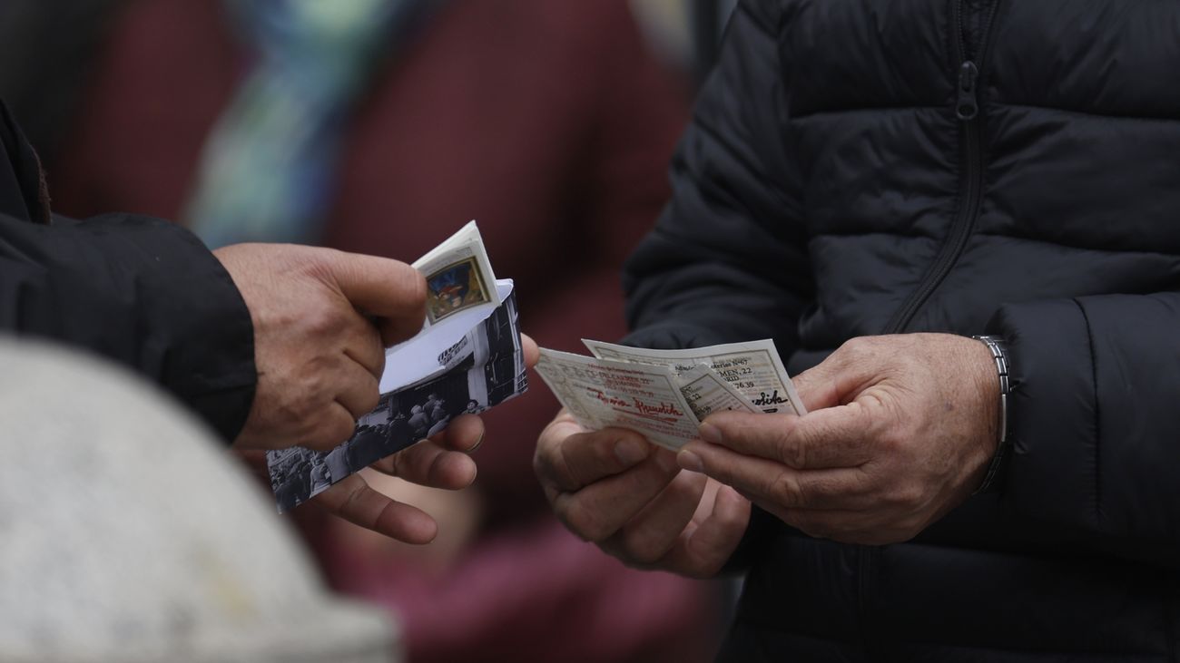 Una persona con varios décimos de lotería de Navidad