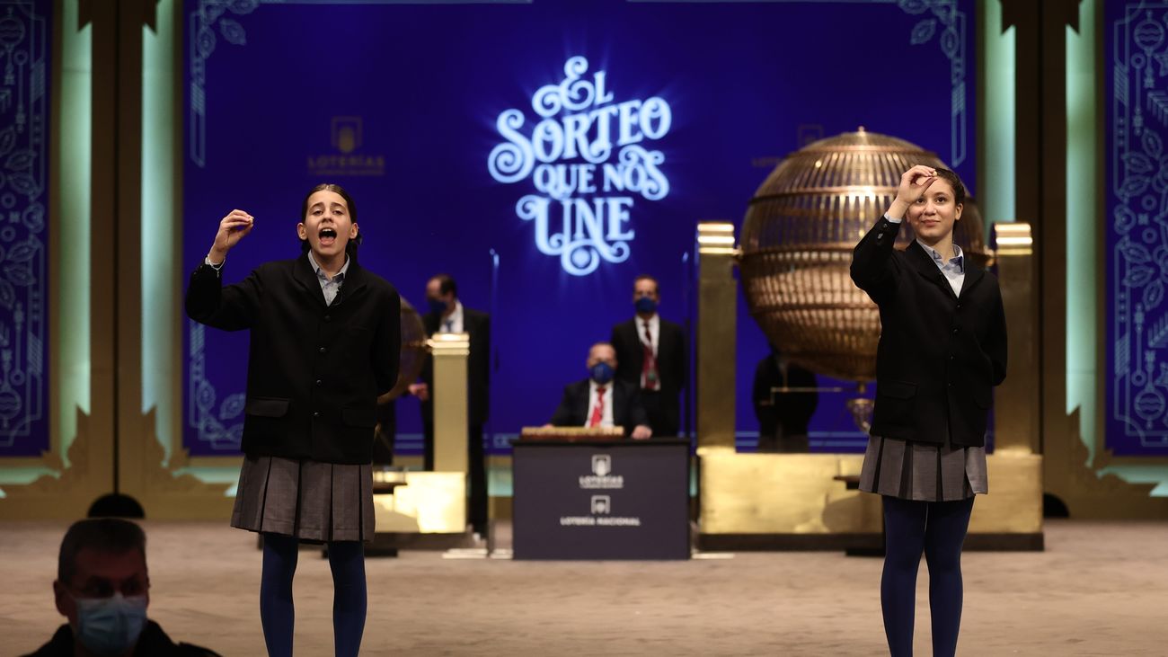 Dos de las niñas de la residencia de San Ildefonso, posan minutos después de cantar un premio durante la celebración del Sorteo Extraordinario de la Lotería de Navida