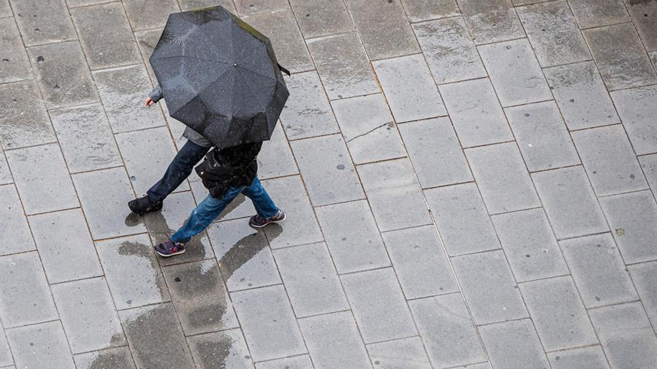 Dos personas bajo un paraguas caminan en medio de la lluvia