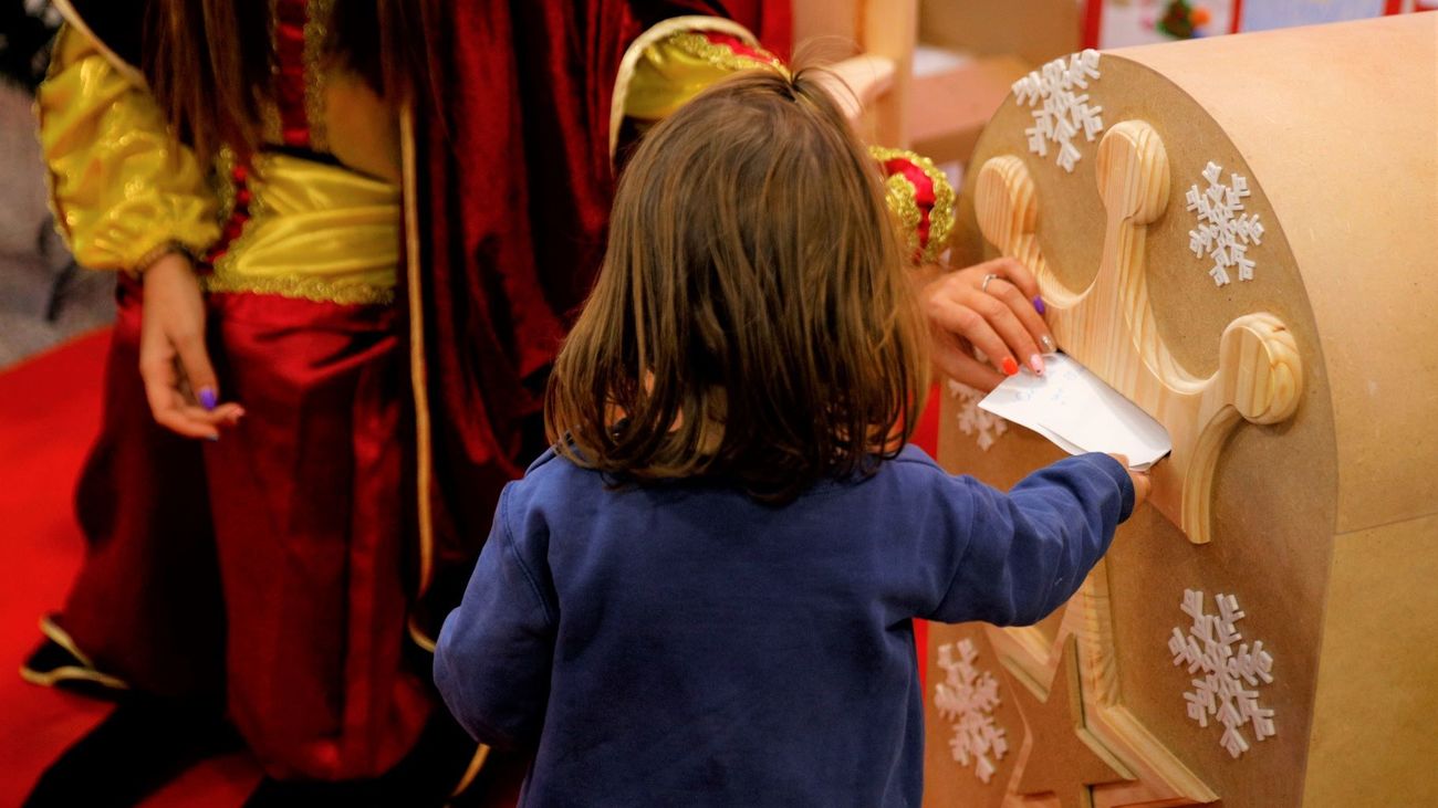 Una niña introduce su carta en el buzón de los Reyes Magos