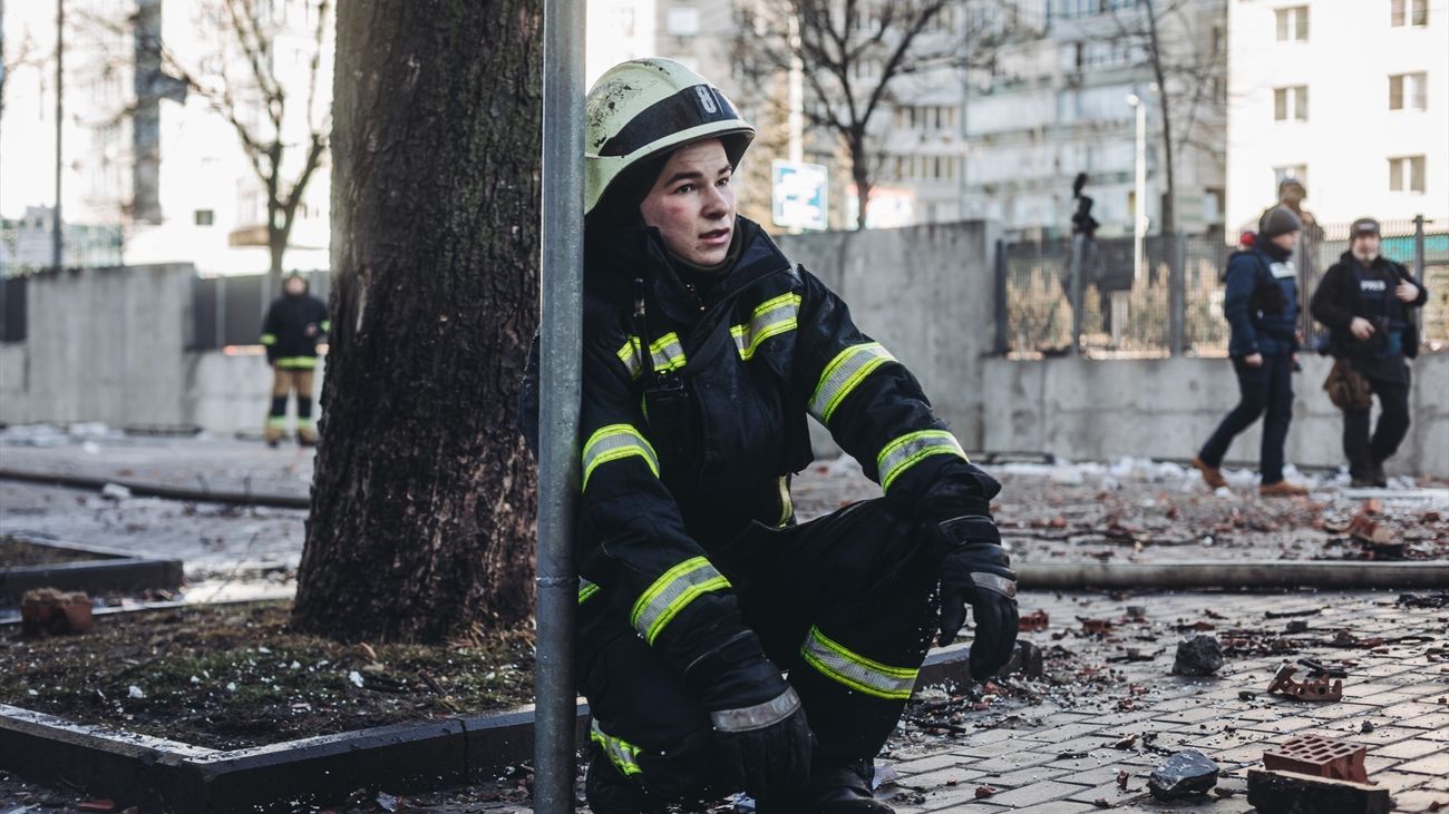 Un bomberos en las inmediaciones del edificio civil bombardeado, en una zona residencial, a 26 de febrero de 2022, en Kiev (Ucrania)