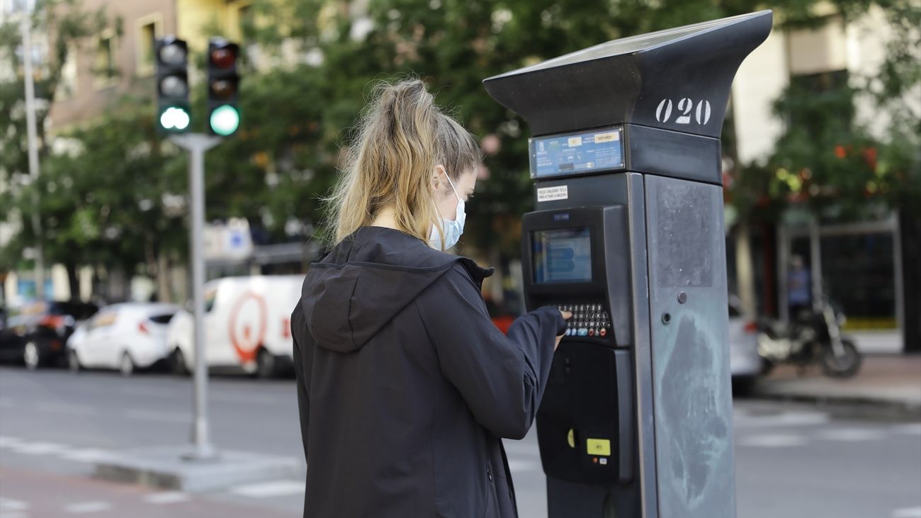 Una joven utiliza un parquímetro del Servicio de Estacionamiento Regulado (SER) de Madrid
