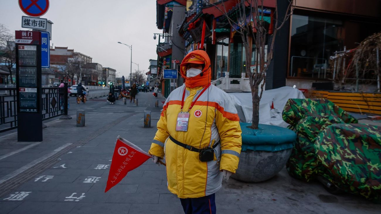 Un guía aguarda la llegada de visitantes al distrito comercial de Pekín (China)