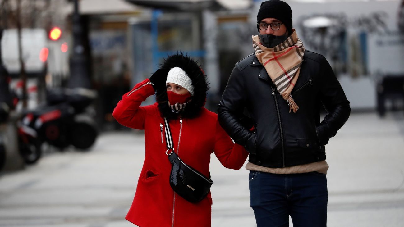 Una pareja pasea abrigados con gorros y bufandas