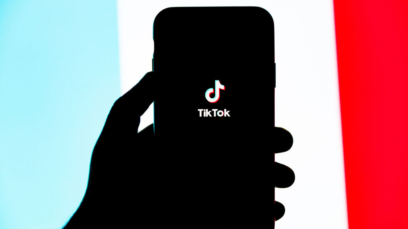 Un usuario sostiene su teléfono móvil con el logo de TikTok