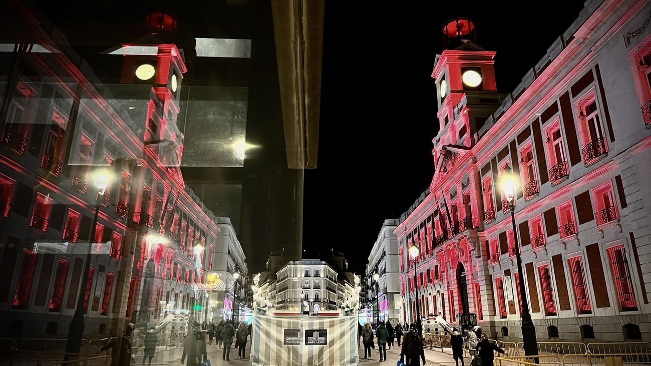 La fachada de la Real Casa de Correos de color carmesí por el cumpleaños del Rey