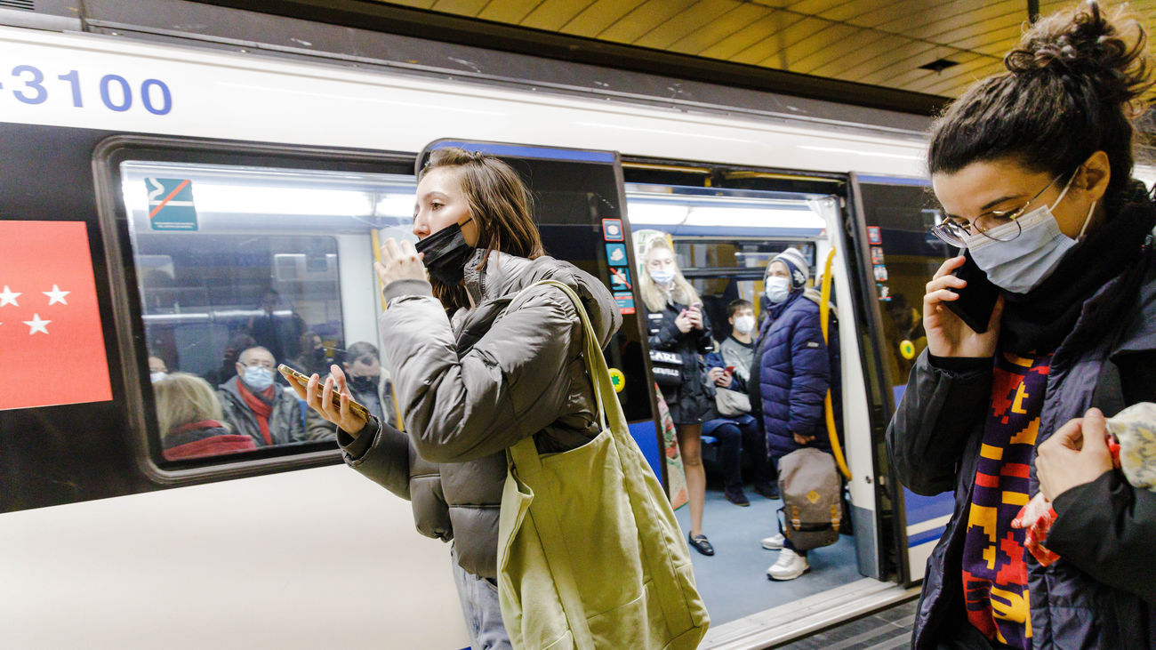 Una mujer se quita la mascarilla tras bajar de un metro en el andén de la estación de Metro de Callao
