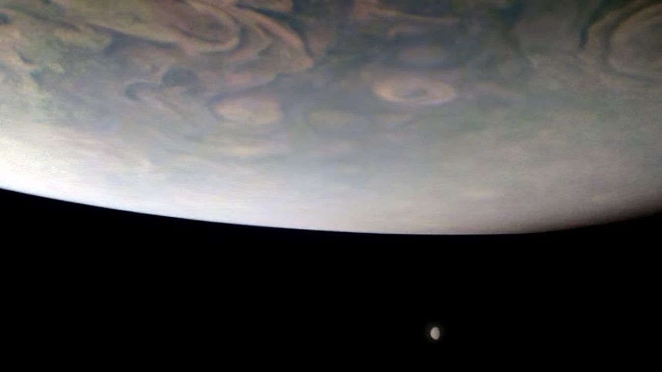 Júpiter aparece sobre dos de sus mayores lunas, captadas en la lejanía