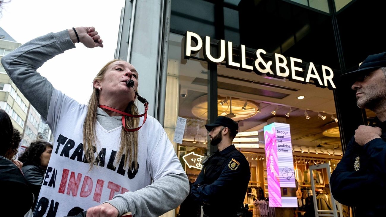 Una mujer se manifiesta frente a una tienda Pull & Bear por una subida salarial