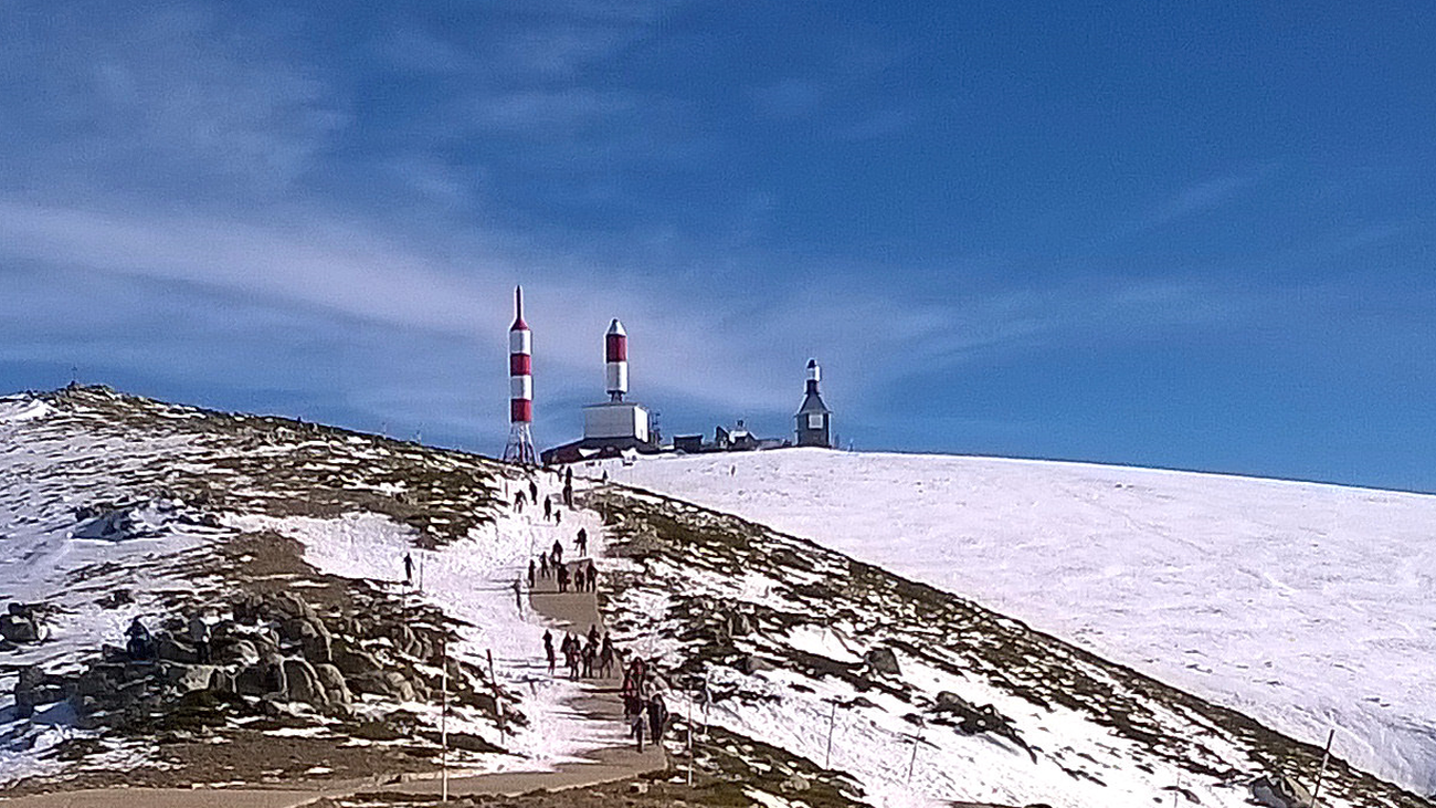 Personas caminan hacía el alto de la Bola del Mundo, en la Sierra de Guadarrama