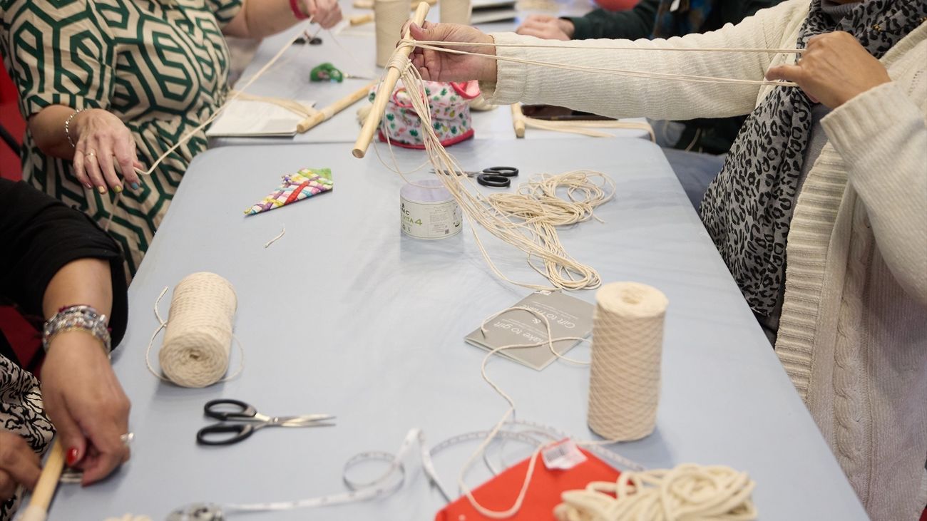Varias personas asisten a un taller de tejer en una feria de ganchillo