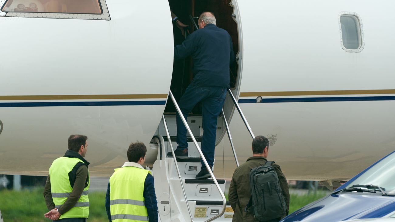 El rey emérito Juan Carlos I sube las escaleras de un avión privado en el aeropuerto vitoriano de Foronda