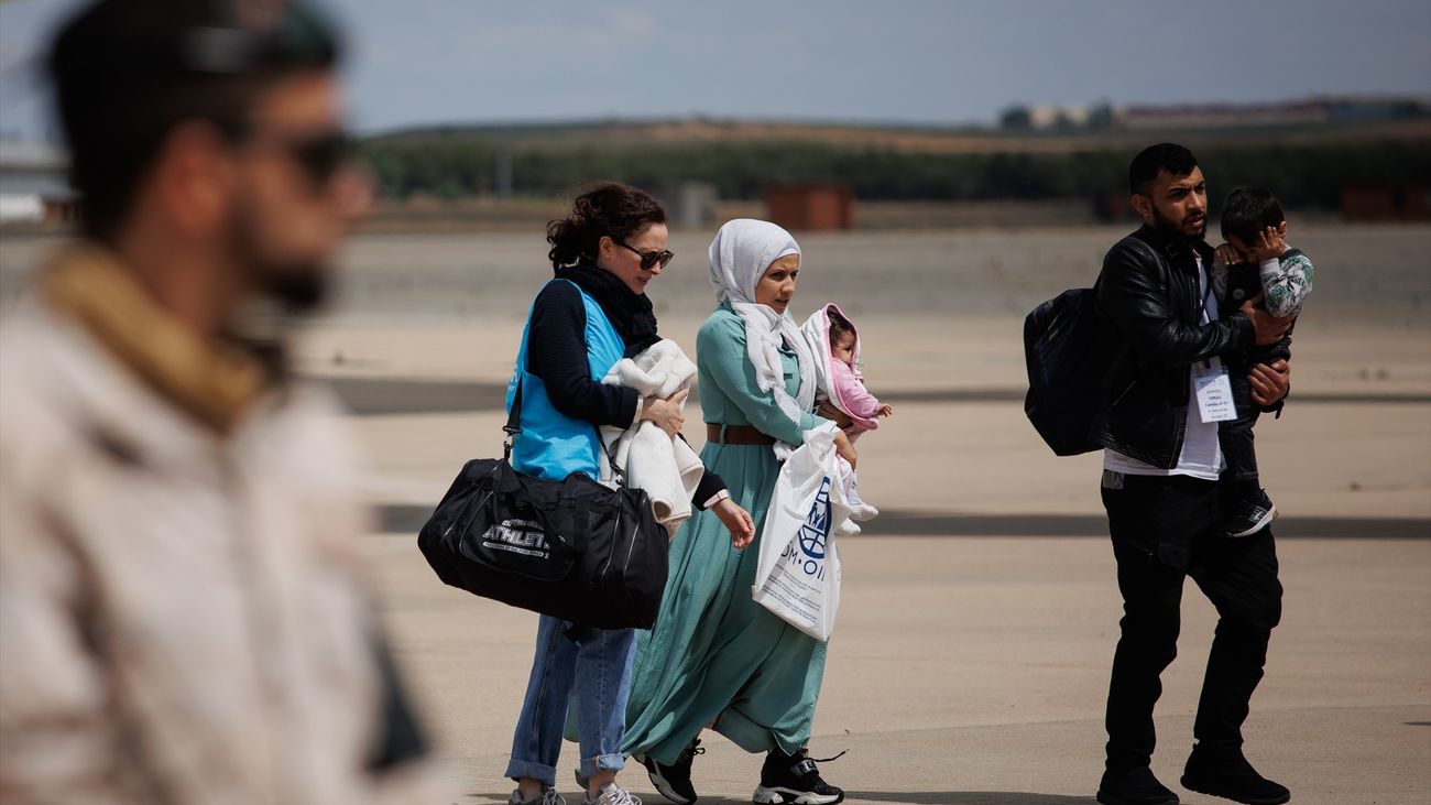 Una familia con dos niños procedentes de Siria a su llegada a la base aérea de Torrejón de Ardoz