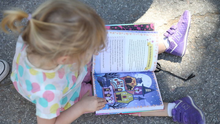 Una niña leyendo un cuento en la FLM / FLM